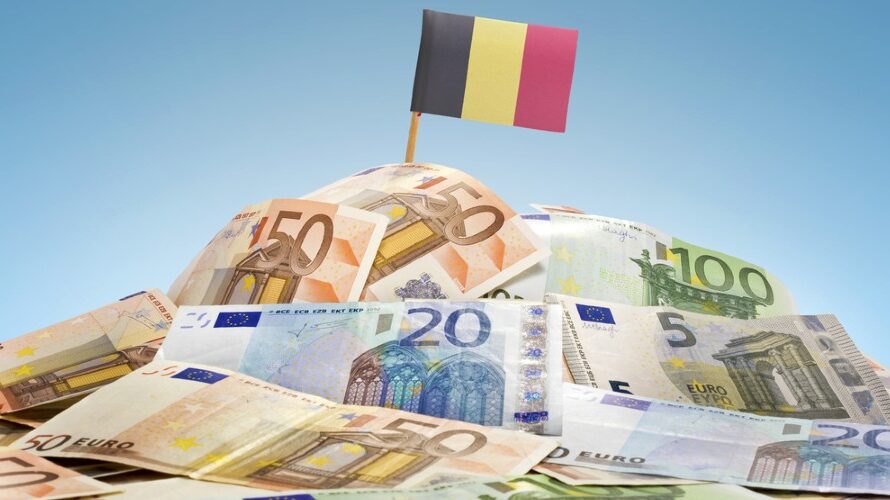 Stapel eurobiljetten met een Belgische vlag erin geplant